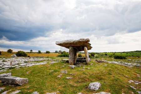 Téléchargez les photos : Poulnabrone Dolmen en Irlande, Royaume-Uni. à Burren, comté de Clare. Période du Néolithique avec un paysage spectaculaire. Soubassement de calcaire karstique exposé au parc national Burren. Rude nature irlandaise - en image libre de droit