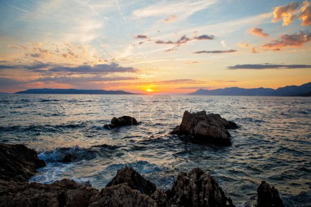 Foto de Increíble puesta de sol en la playa con horizonte infinito e increíbles olas espumosas - Imagen libre de derechos