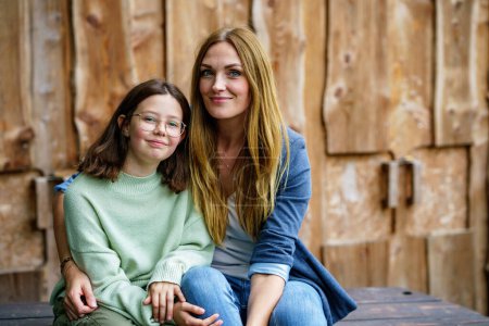 Photo for Portrait of little school girl with glasses and mother hugging together. Cute daughter and happy woman. family, childhood, happiness and people. - Royalty Free Image