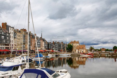 Téléchargez les photos : HONFLEUR, FRANCE - 23 août 2022 : Vue sur le port pittoresque d'Honfleur, les yachts et les vieilles maisons reflétés dans l'eau. - en image libre de droit