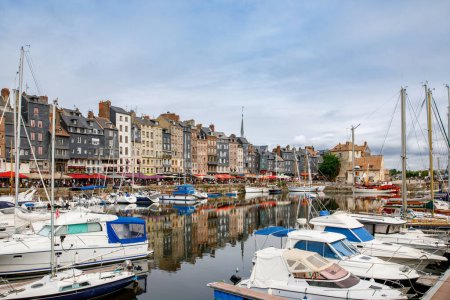 Téléchargez les photos : HONFLEUR, FRANCE - 23 août 2022 : Vue sur le port pittoresque d'Honfleur, les yachts et les vieilles maisons reflétés dans l'eau. - en image libre de droit