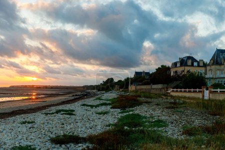 Photo for Sunrise view of coastal street of Grandcamp Maisy, a scenic French coastal town in Normandy, with fishing port, sandy beaches, and maritime traditions - Royalty Free Image