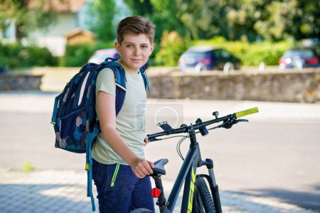 Photo for Handsome preteen boy going to school on bike. Teenager ride bicycle. Safe way to high school. Happy child boy with backpack on bike. Healthy outdoor activity for young student - Royalty Free Image