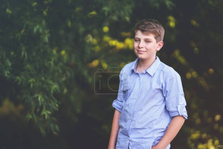 Téléchargez les photos : Handsome Teenager Boy Poses en plein air, Exuding Confidence and Style in a Captivating Portrait. Joyeux préadolescent enfant - en image libre de droit