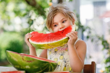 Photo for Little Girl, Preschooler, Delights in a Juicy Watermelon on a Sunny Summer Day. Child sharing a Healthy Snack with Her Family, She Embraces the Joy of Summertime Bliss. - Royalty Free Image