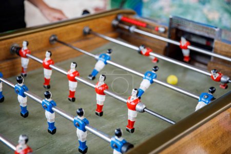 Photo for Close-up of kid boy playing table soccer. Happy excited child having fun with family game with siblings or friends. Positive kid - Royalty Free Image