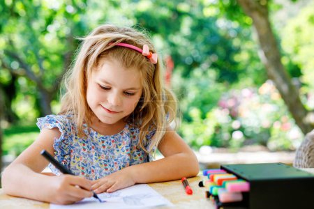 Photo for Cute Little Preschooler Child Drawing at Home. Happy Girl with Colorful Felt Pens. Hobby for Children. Leisure Activity for Small Kids - Royalty Free Image