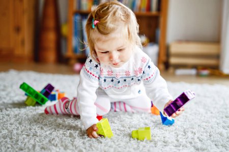 Photo for Adorable Toddler Girl Playing with Educational Toys in Nursery. Happy Healthy Child Having Fun with Colorful Different Plastic Blocks at Home. Cute Baby Learning, Creating, and Building - Royalty Free Image