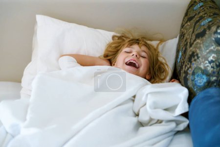 Foto de Linda niña preescolar después de dormir en la cama. Adorable sueño infantil preescolar, sueño saludable de los niños durante el día. Dormir profundamente del niño pequeño. Niños Descansando - Imagen libre de derechos