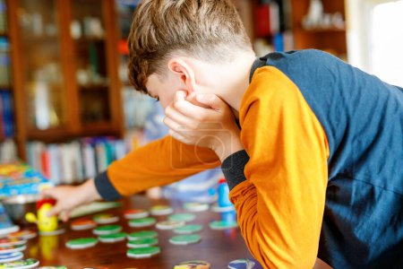 Photo for Family playing board game at home. Kids play strategic game. Little sister girl and two school brothers boys. Fun indoor activity. Siblings bond. Educational toys - Royalty Free Image