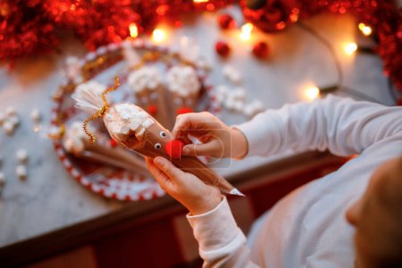 Foto de Niña preescolar sosteniendo renos hechos con cacao en polvo de chocolate y malvaviscos. Bebida de postre hecha a sí misma para niños en Navidad - Imagen libre de derechos