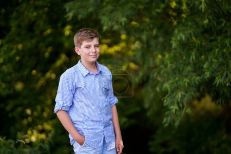 Téléchargez les photos : Handsome Teenager Boy Poses en plein air, Exuding Confidence and Style in a Captivating Portrait. Joyeux préadolescent enfant - en image libre de droit