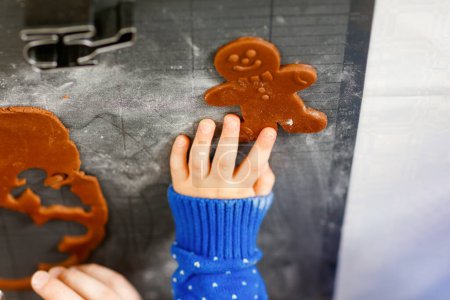 Photo for Close-up of hands of little preschool boy and father baking gingerbread cookies. Close up of son and dad, man in xmas sweaters. Kitchen decorated for Christmas. Christmas family activity. - Royalty Free Image