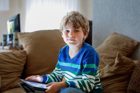 Photo for School boy with tablet computer. Schoolchild study online. Electronic device for learning, studying and playing at home. Little boy with laptop pc. Gadget and screen time for children. Kid at home - Royalty Free Image
