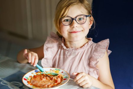 Téléchargez les photos : Little preschool girl eating from spoon vegetable potato soup. Healthy food for children. Happy kid at home or nursery - en image libre de droit