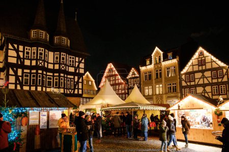 Photo for ALSFELD, GERMANY - 9 December, 2022: : Old market place with the christmas decoration, old houses with stores, restaurants and visitors of the christmas market. Traditional Christmas market. - Royalty Free Image