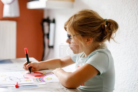 Niedliche kleine Vorschulkind zeichnen zu Hause. Glückliches Mädchen mit bunten Filzstiften. Hobby für Kinder. Freizeitaktivitäten für kleine Kinder in der Schule