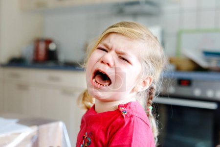 Foto de Lindo molesto infeliz niña llorando. Un niño emocionalmente enojado gritando. Retrato de niño con lágrimas - Imagen libre de derechos