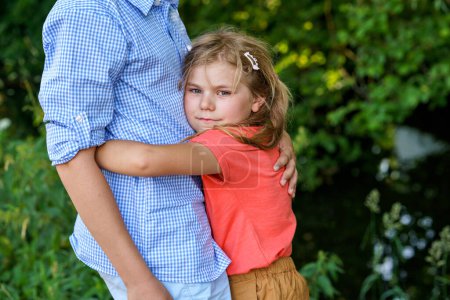 Photo for An upset little girl finds comfort in the embrace of her caring teenage brother, exemplifying the bond of a loving family. Loving Siblings, Brother and Sister - Royalty Free Image
