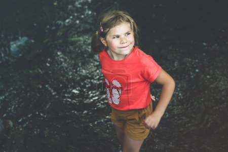 Photo for A Happy Girl Embraces the Joys of Childhood as She Explores a Summer Creek, Immersing Herself in Natures Wonders and Playful Discoveries. Preschool Child and Summertime - Royalty Free Image