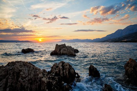 Foto de Increíble puesta de sol en la playa con horizonte infinito e increíbles olas espumosas - Imagen libre de derechos