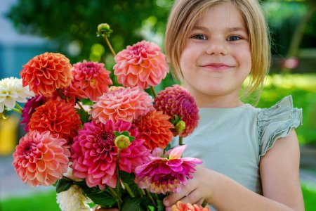 Photo for Close up of little preschool girl with dahlia flower bouquet. Close-up of happy child holding colorful garden summer flowers for mothers day or birthday. Closeup of flowers in rainbow colors - Royalty Free Image