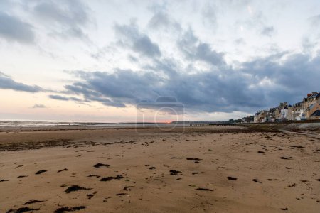 Vista del amanecer de la calle costera del Grandcamp Maisy, una pintoresca ciudad costera francesa en Normandía, con puerto pesquero, playas de arena y tradiciones marítimas