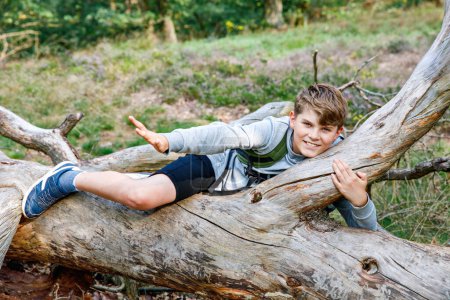 Téléchargez les photos : Adolescent garçon randonnée dans la forêt le jour de l'été. Ecole enfant s'amuser avec des loisirs actifs pour la famille - en image libre de droit