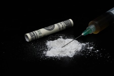 Foto de Cocaína u otras drogas ilegales, polvo blanco, jeringa, aislada sobre fondo negro brillante - Imagen libre de derechos