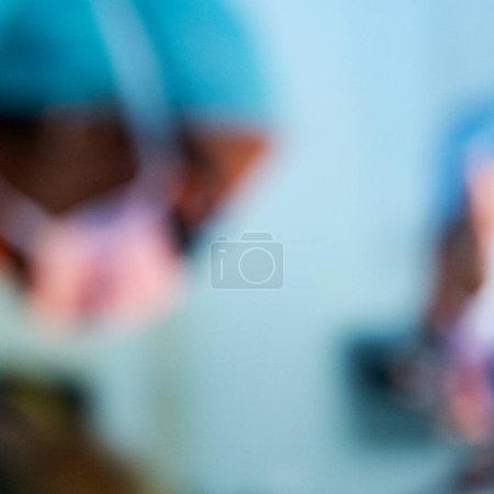 Photo for London UK, November13 2022, Anonymous Blurred Doctors Or Medical Staff Working In A Hospital Wearing Blue Gowns And Protective Face Masks - Royalty Free Image