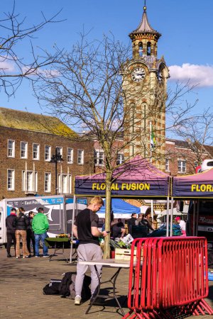Foto de Epsom Surrey, Reino Unido, 30 de marzo de 2024, Mercado tradicional al aire libre y torre del reloj Epsom bajo un cielo azul - Imagen libre de derechos