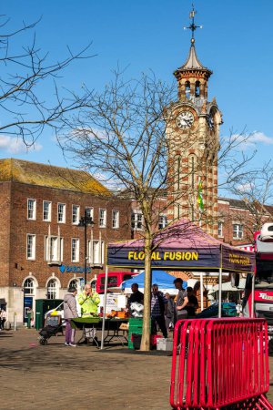 Foto de Epsom Surrey, Reino Unido, 30 de marzo de 2024, Mercado tradicional al aire libre y torre del reloj Epsom bajo un cielo azul - Imagen libre de derechos