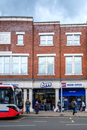 Foto de Epsom Surrey, Reino Unido, 02 de abril 2024, tienda de descuento de B & M con personas o compradores fuera y un estacionamiento de papelería de un solo piso Falcon Bus - Imagen libre de derechos