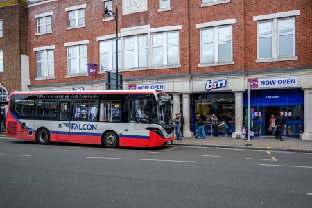 Foto de Epsom Surrey, Reino Unido, 02 de abril 2024, tienda de descuento de B & M con personas o compradores fuera y un estacionamiento de papelería de un solo piso Falcon Bus - Imagen libre de derechos