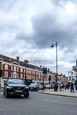 Foto de Epsom, Surrey, Reino Unido Abril 03 2024, Moter Vehículos o coches que se alejan de los semáforos en un cruce de carreteras importante con peatones en el pavimento - Imagen libre de derechos