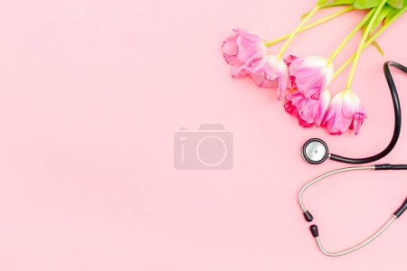 National Doctor's or nurse day greeting card with stethoscope, bunch of tulips flowers on pink background.Health medicine Day.Copy space for text.mockup.