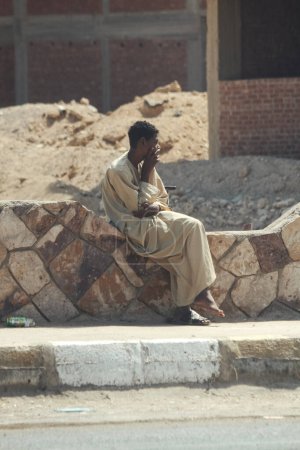 Photo for Arab guy sitting against the background of a destroyed house, war, human destinies - Royalty Free Image