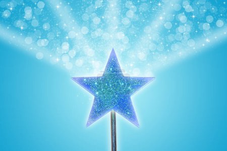 Foto de Polvo de estrella mágica fluyendo desde la parte superior de la varita mágica azul brillante. - Imagen libre de derechos
