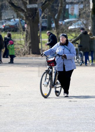 Téléchargez les photos : HANNOVER, ALLEMAGNE-30 MARS : Vieille femme non identifiée avec un vélo près du lac Maschsee. 30 mars 2018 à Hanovre, Allemagne - en image libre de droit