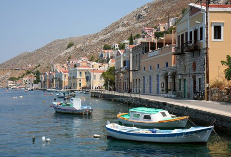 Téléchargez les photos : SYMI, GRÈCE-14 JUILLET : Bateaux de pêche et maisons grecques colorées au bord de la mer. 14 juillet 2013 à Symi, Grèce - en image libre de droit