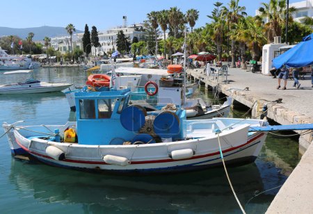 Téléchargez les photos : Kos, Grèce-12 mai 2019 : Bateaux de pêche amarrés au port près des palmiers - en image libre de droit