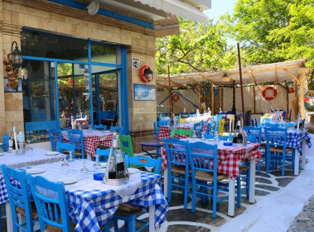 Téléchargez les photos : Kos, Grèce-12 mai 2019 : Restaurant grec traditionnel de fruits de mer avec chaises et nappes colorées - en image libre de droit