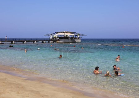 Téléchargez les photos : FAMAGUSTA, NORD CHYPRE-AOÛT 31 2023 : Personnes non identifiées nageant près du Beach Bar - en image libre de droit