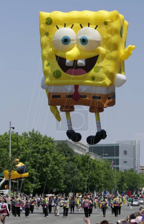 Photo for INDIANAPOLIS, IN, USA-MAY 23,2009:Unidentified people walking with SpongeBob SquarePants Balloon at Indy 500 Parade - Royalty Free Image