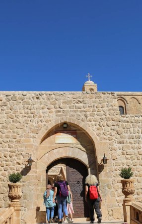 Téléchargez les photos : MARDIN, TURQUIE-OCTOBRE 09,2021 : Touristes non identifiés entrant dans le monastère assyrien de Deyrulzafaran - en image libre de droit