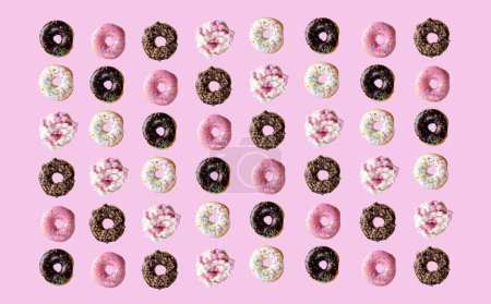 Téléchargez les photos : Une collection de beignets sur fond rose pastel - en image libre de droit