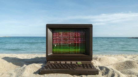 Photo for Retro computer on a beach with data and code on screen - Royalty Free Image