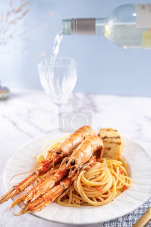 A plate with seafood for the festive table. Pasta with Norwegian lobster and white wine. Food for gourmets. Free space for text.