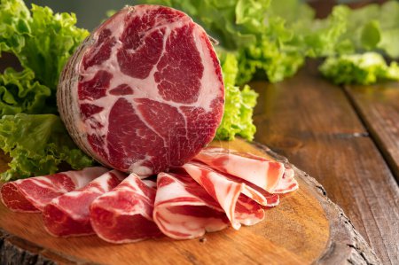 Photo for Capocollo or coppa is a traditional Italian and Corsican pork cut made from cured pork shoulder or neck. . Cut into very thin slices. Italian delicacy for aperitivo. Piacentina DOP. - Royalty Free Image