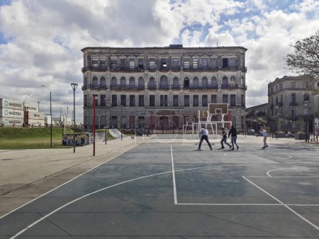 Foto de MONTEVIDEO, URUGUAY, SEPTEMBER - 2021 - Teens platyng at public sports court, ciudad vieja neigborhood, montevideo, uruguay - Imagen libre de derechos